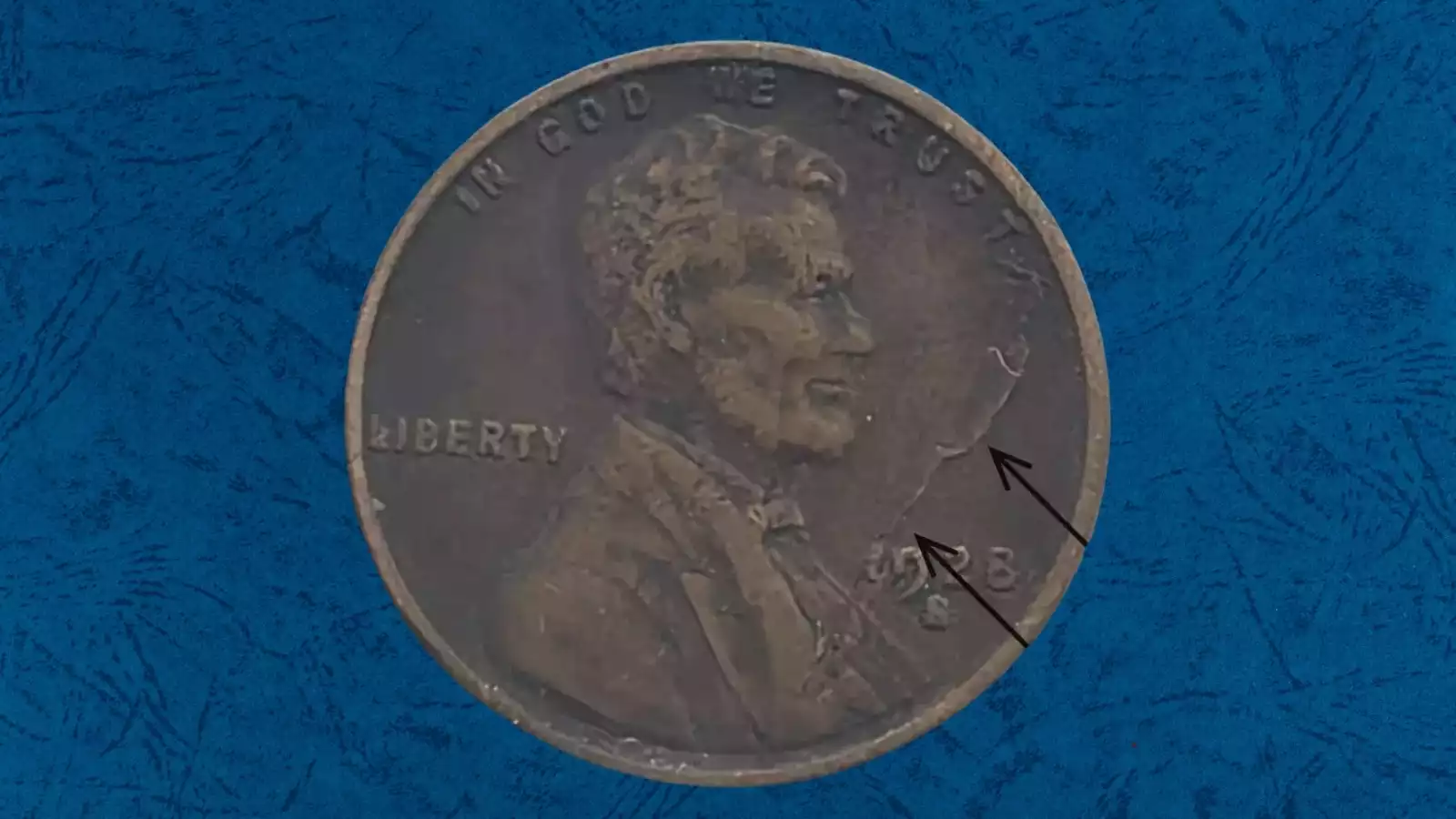 1928 wheat penny BIE die crack error close-up showing raised vertical line between B and E in the LIBERTY legend on the obverse